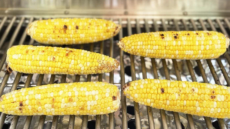 Ears of corn on grates of a grill. 