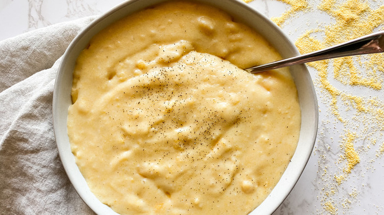 Bowl of creamy corn polenta with black pepper. 