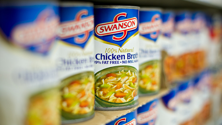 Row of canned chicken broth at store