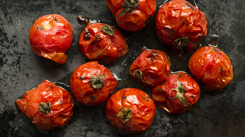 roasted whole canned tomatoes on a dark background