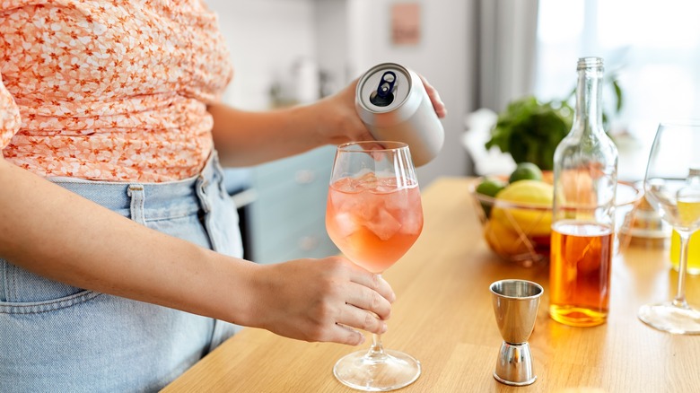 Woman pouring canned wine in glass