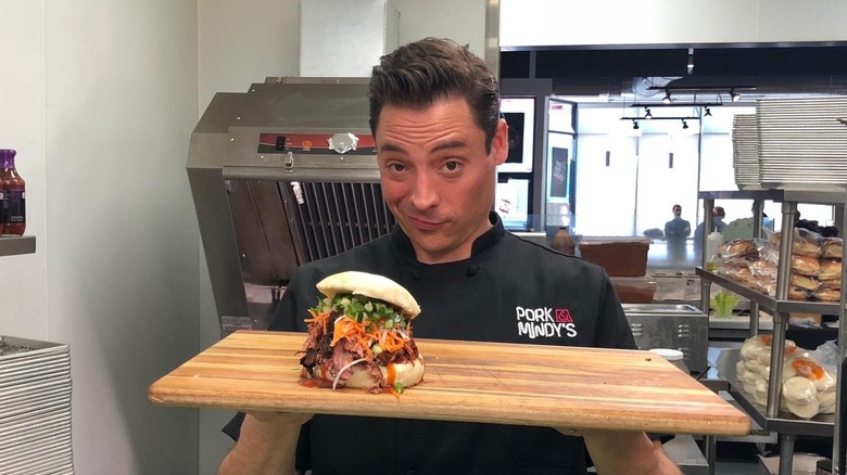 Jeff Mauro with sandwich in kitchen