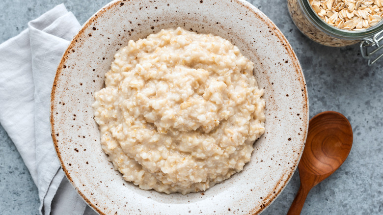 oatmeal in a speckled bowl with wooden spoon and cloth napkin