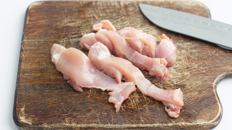 Sliced boneless chicken on cutting board