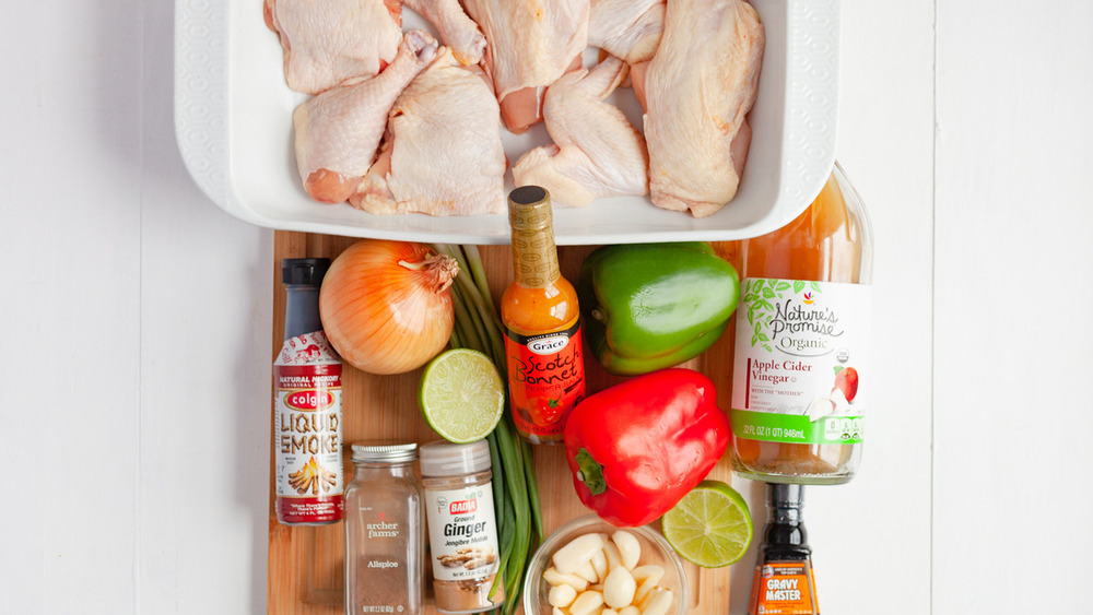 Raw chicken pieces, scotch bonnet sauce and other ingredients on the counter