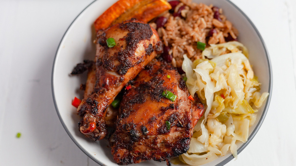 Plate of jerk chicken with side dishes