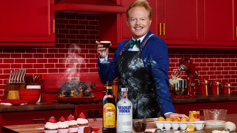 Jesse Tyler Ferguson holding cocktail in kitchen