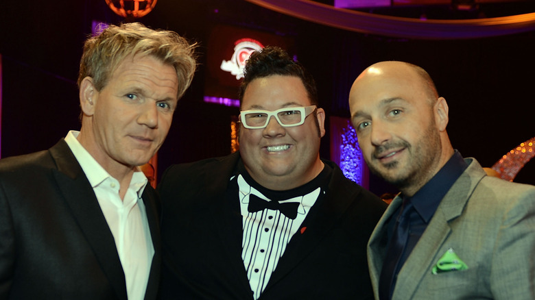 Joe Bastianich standing and smiling with Gordon Ramsey and Graham Elliot