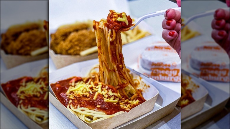 Jolly Spaghetti on a fork with other Jollibee food in background