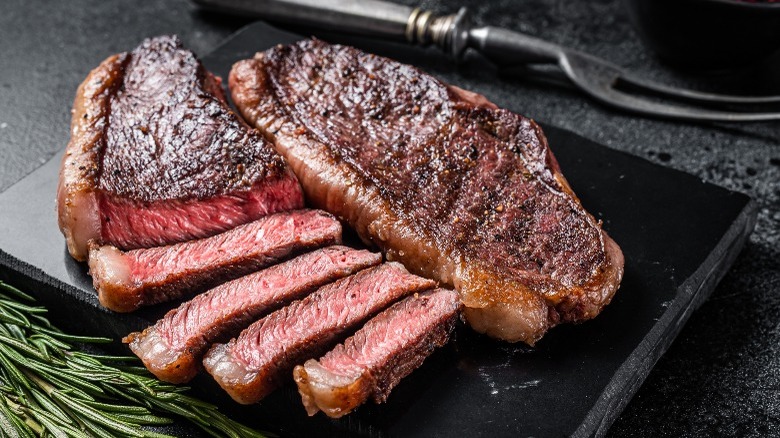 Steak sliced on black plate