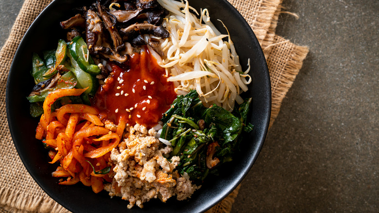 Bibimbap in cast iron skillet on burlap fabric