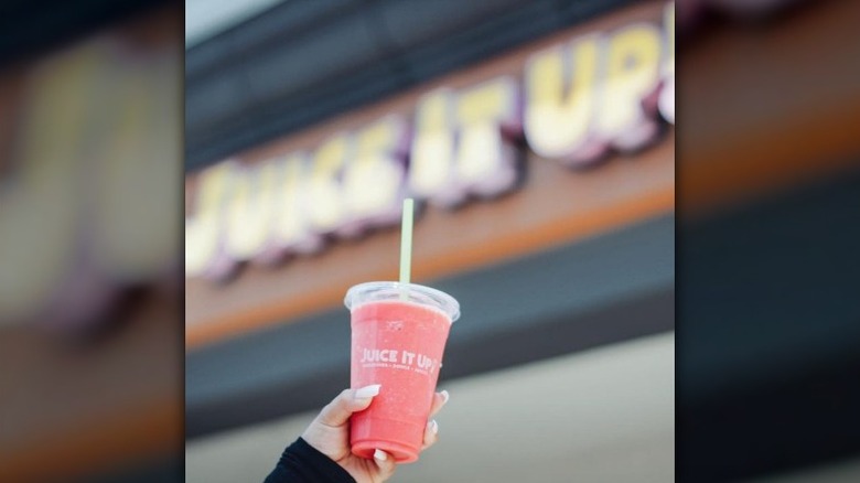 hand holding pink smoothie