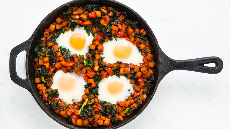 Sweet potato hash with eggs in skillet