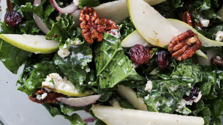 close up kale salad with pears and maple pecans