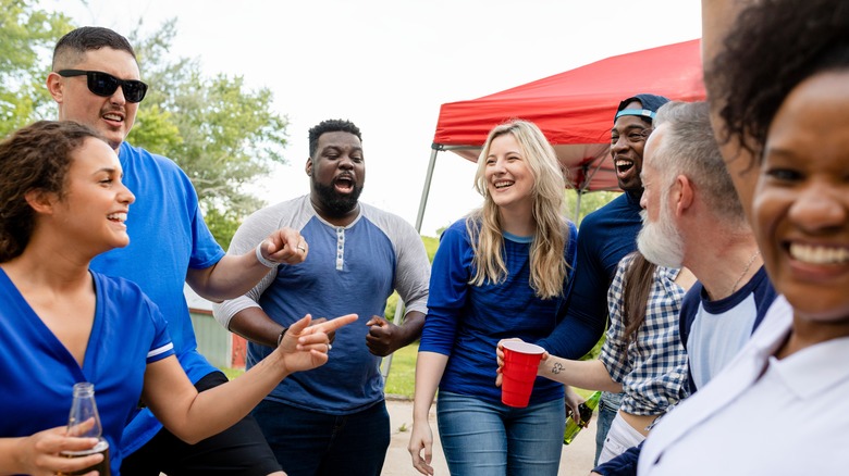 People socializing at tailgate party