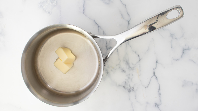 Pats of butter in saucepan