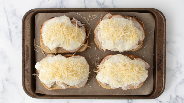 Four open-faced sandwiches with Parmesan cheese