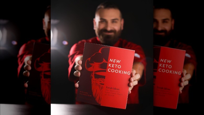 Chef Michael holding first keto cookbook