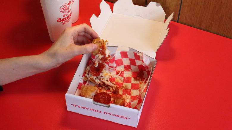 holding fried chicken with cheese