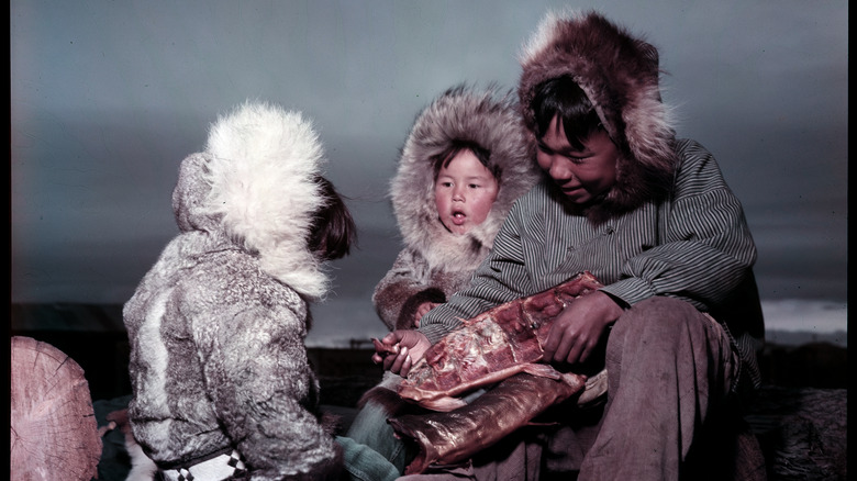 Inuit family eating meat