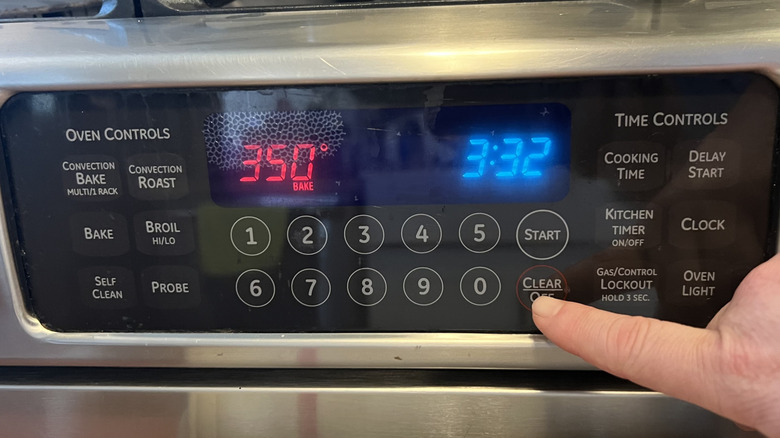 hand setting oven to preheat on display