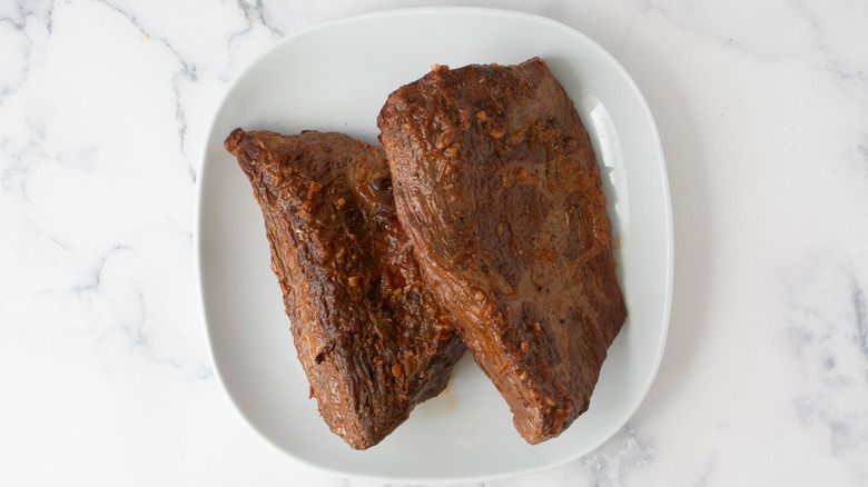 seared brisket meat resting on plate