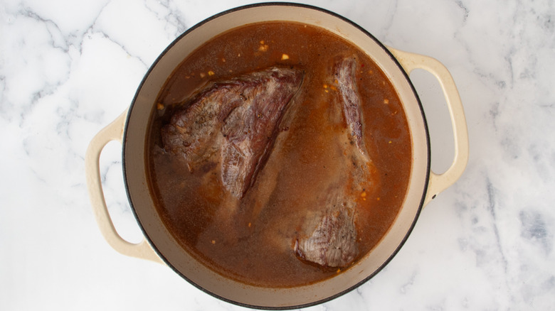 brisket with diluted sauce in pot