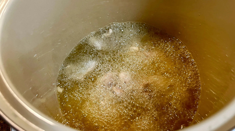 Chicken frying in bubbling oil