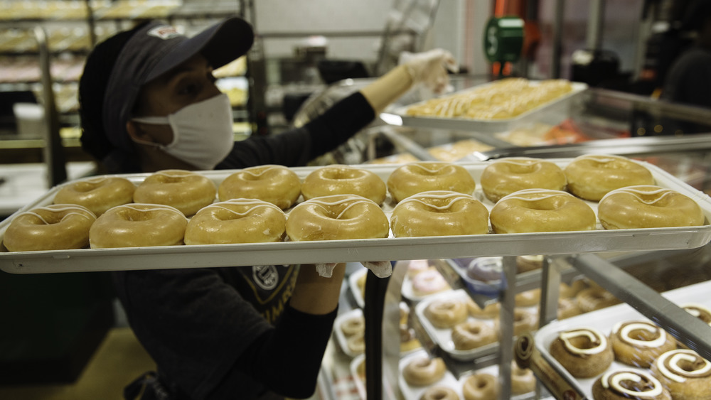 Krispy Kreme worker with tray of donuts