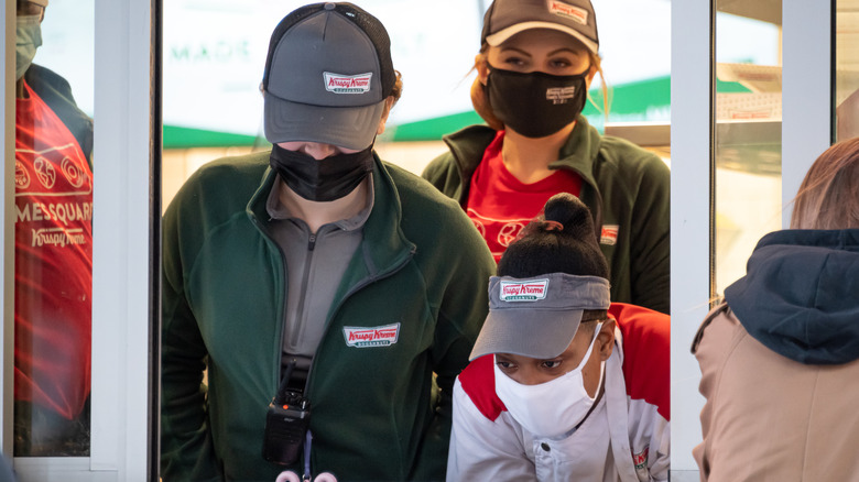 Krispy Kreme workers at a takeout window