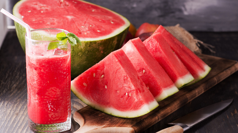 Cold cut up watermelon and a glass of watermelon juice