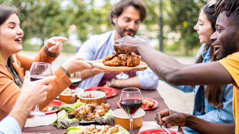 people eating grilled chicken at dinner party