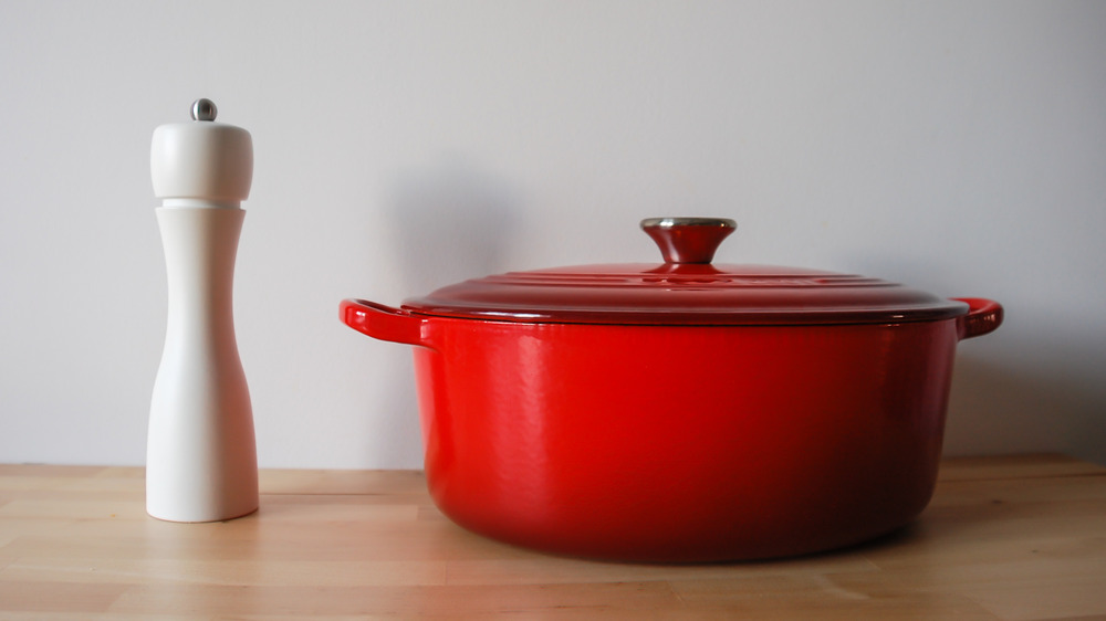 Le Creuset pot next to a white pepper grinder