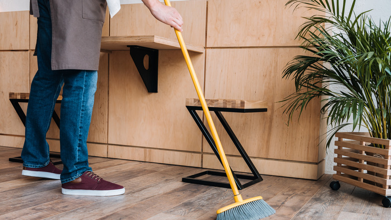 Person sweeping floor of restaurant