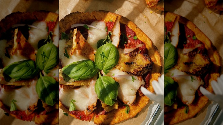 sweet potato pizza crust topped with chicken, cheese, and fresh basil