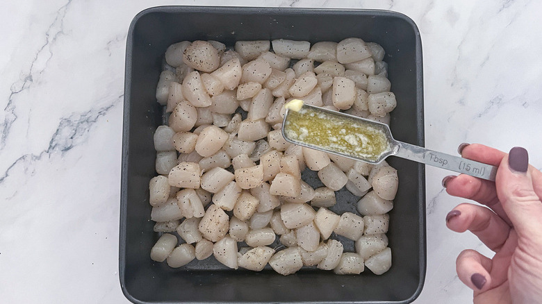 pouring butter onto scallops