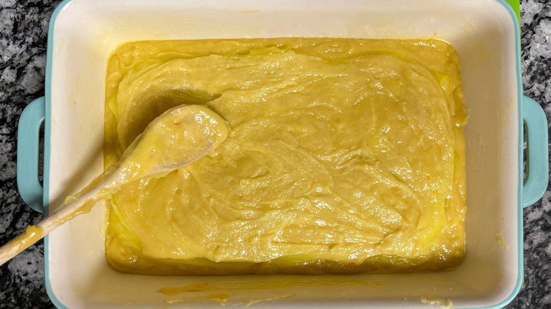 Spoon spreading cake batter out in baking dish