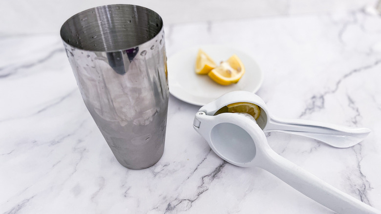 a cocktail shaker and lemon juicer