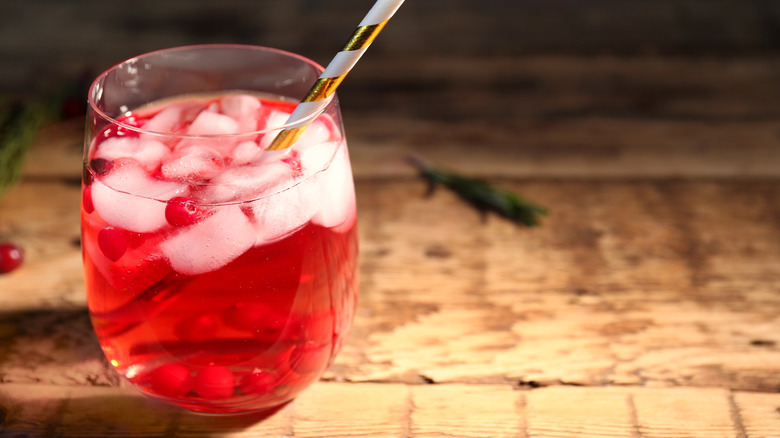 A class of cranberry spritz with a straw