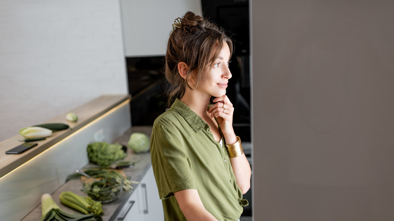 woman looking into freezer