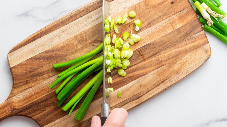 slicing scallions half chopped on cutting board