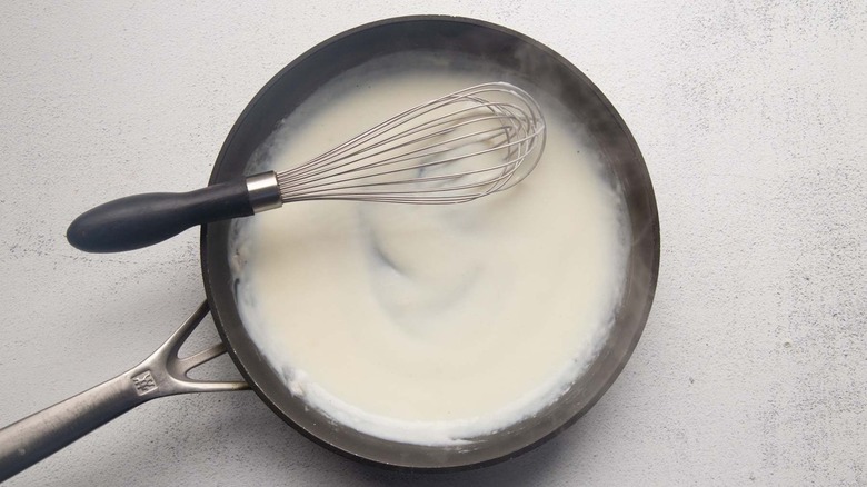 white sauce in frying pan with whisk