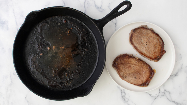 skillet and steaks on plate