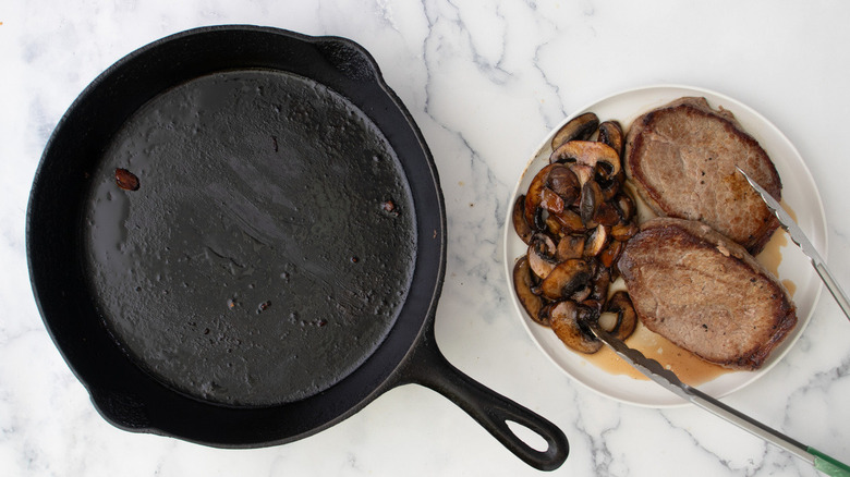 empty skillet and mushrooms with steaks