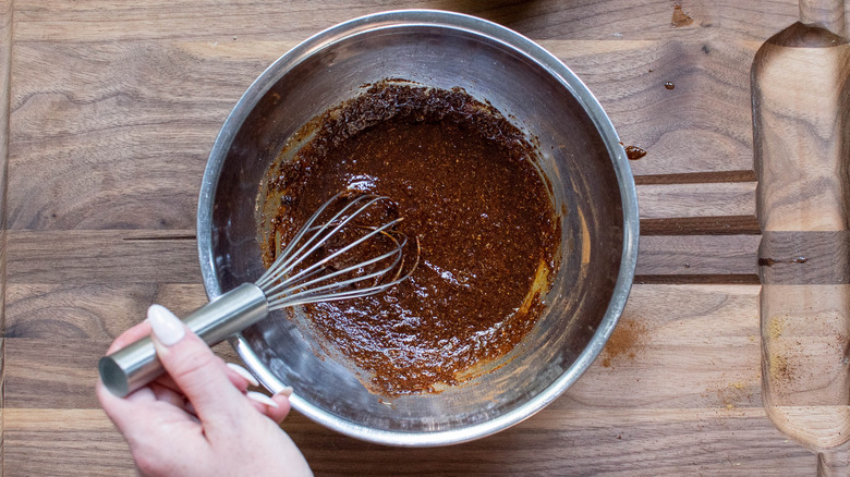 marinde in bowl with whisk