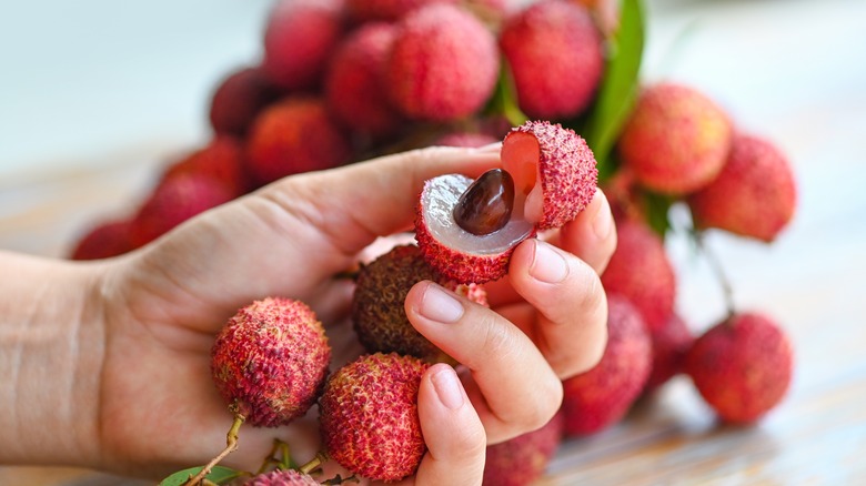 hand holding split lychee fruit