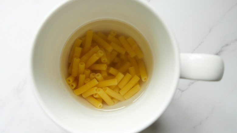 water and macaroni in mug