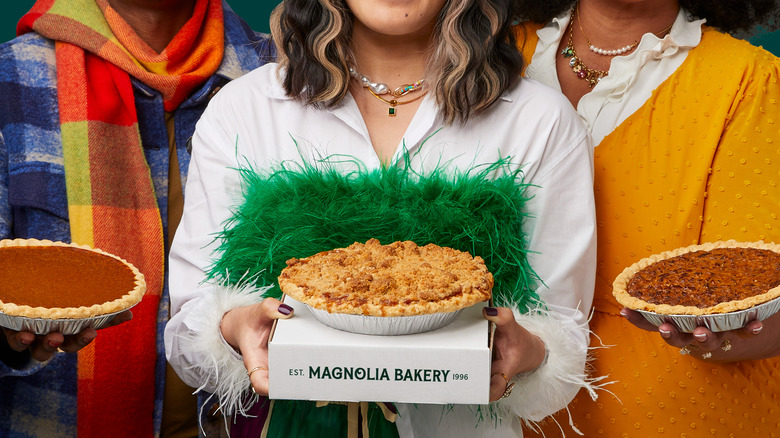 three people each holding a pie