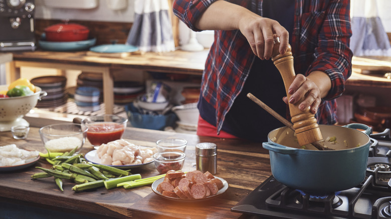 person making food in pot