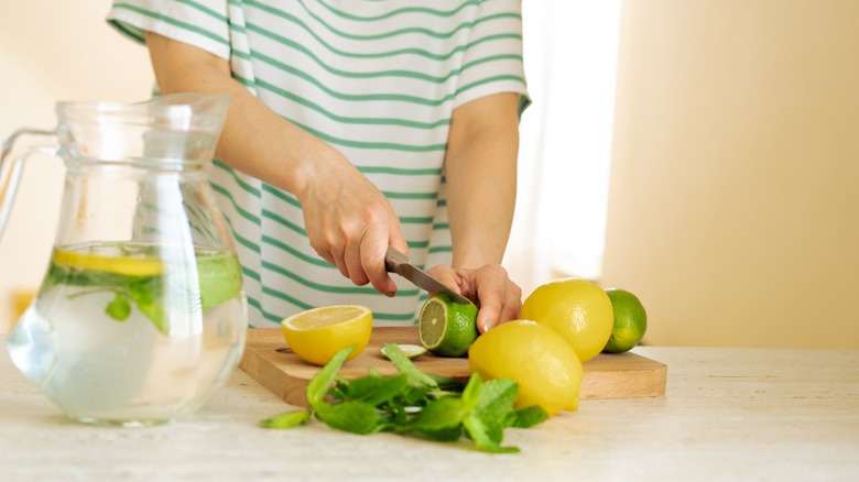 Someone slicing up a lime in preparation to make lemonade